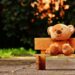 Brown Teddy bear sitting on a wooden chair.