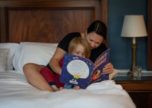 Mother and daughter reading a book together in bed