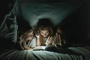 Mother reading a book on her children
