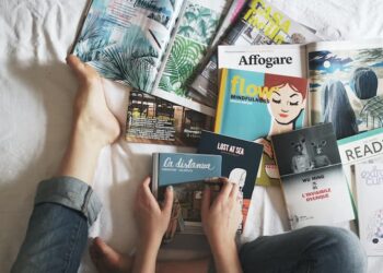 A person holding a book in her bed