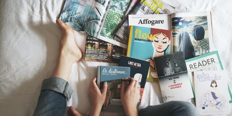 A person holding a book in her bed