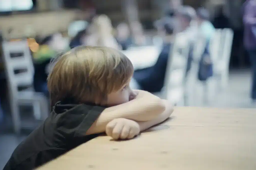 A Boy Leaning Alone on a Table at School 