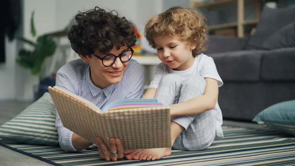 A little girl enjoys reading a book with her mother